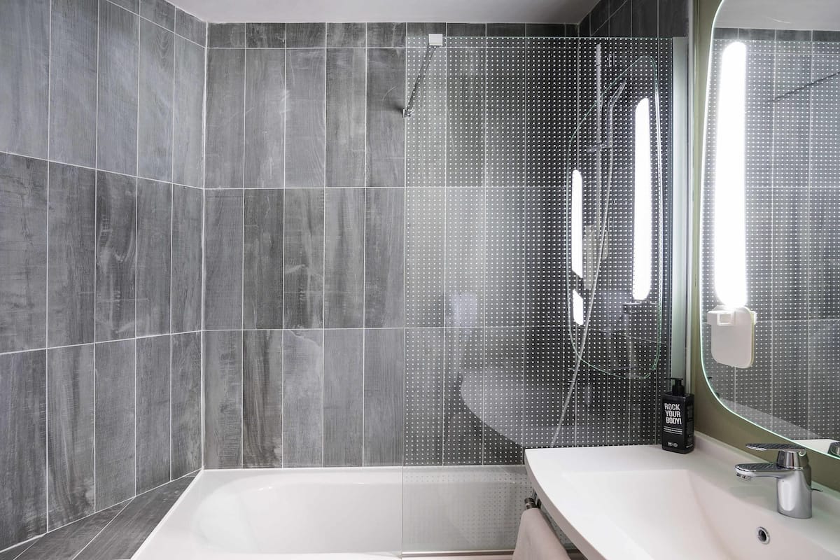 A modern bathroom with a bathtub, a sink, and a shower area.