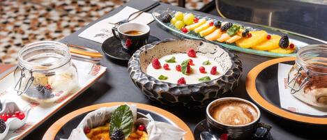 A table with various dishes, a cup of coffee, and a glass jar.