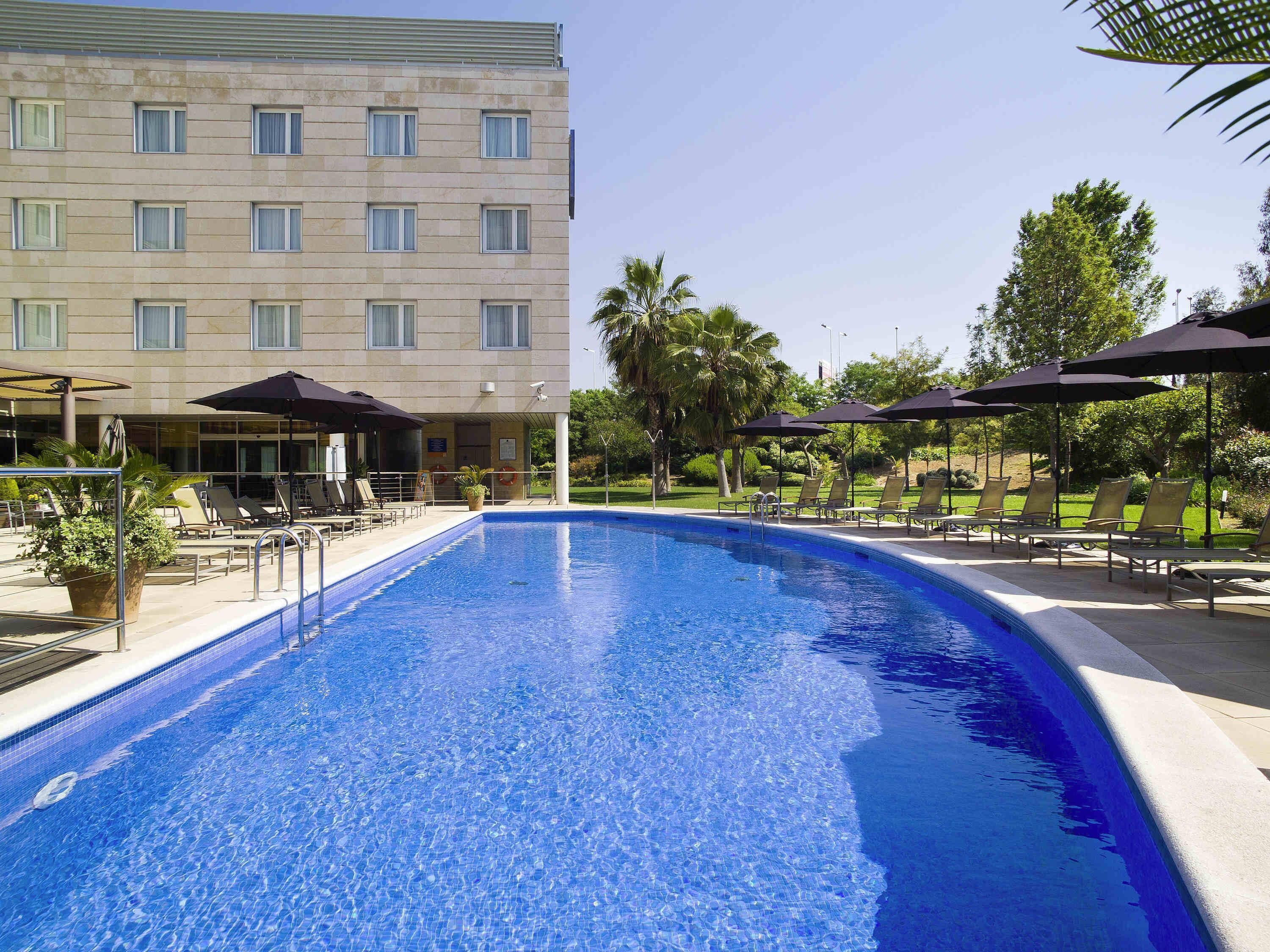 Una piscina al aire libre, sombrillas
