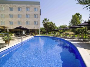 Una piscina al aire libre, sombrillas