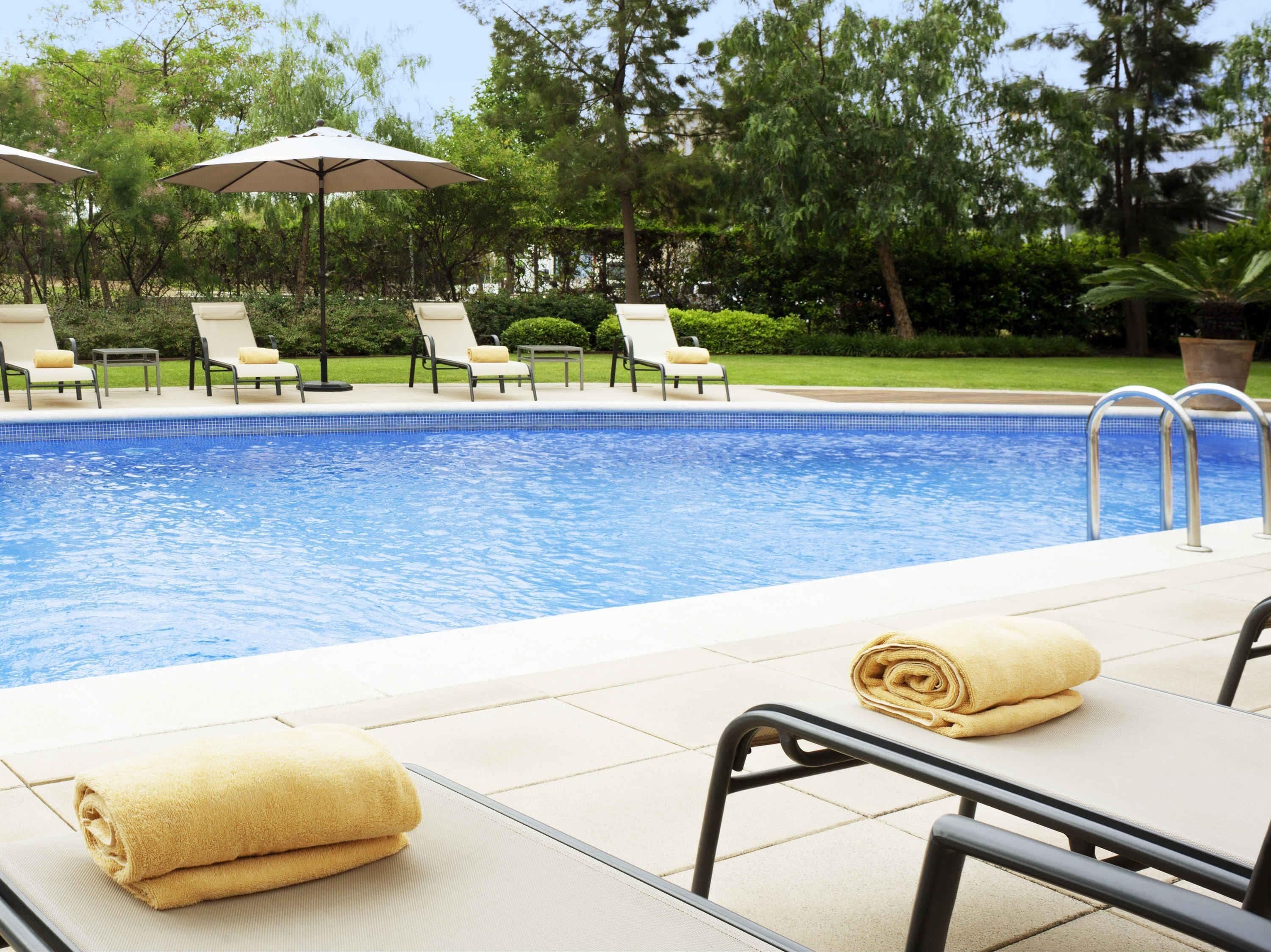 Una piscina al aire libre, sombrillas