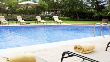 Una piscina al aire libre, sombrillas