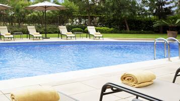 Una piscina al aire libre, sombrillas