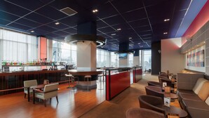 A modern bar area with seating and a counter. - Novotel London ExCeL (London)