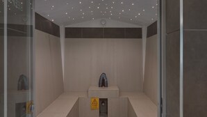 A modern elevator with a warning sign, a small sculpture, and a ceiling with lights. - Novotel London ExCeL (London)