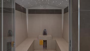 A modern elevator with a warning sign, a small sculpture, and a ceiling with lights.