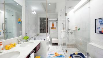 Un baño moderno con cabina de ducha de vidrio, una bañera y un espejo grande.