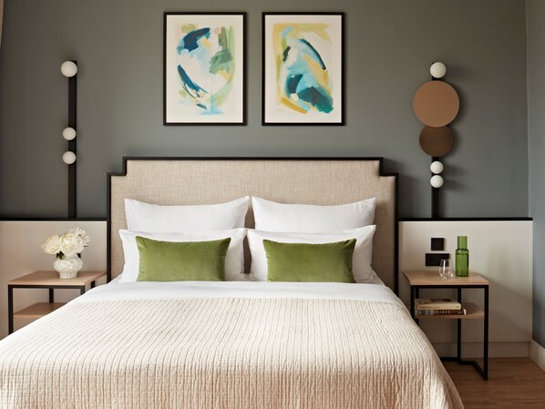 A neatly arranged bedroom with a large bed, two bedside tables, and abstract art on the wall. - Numa Berlin Checkpoint Charlie (Berlin)