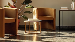 A modern living room with two armchairs, a small round table, and a potted plant. - Numa Berlin Checkpoint Charlie (Berlin)
