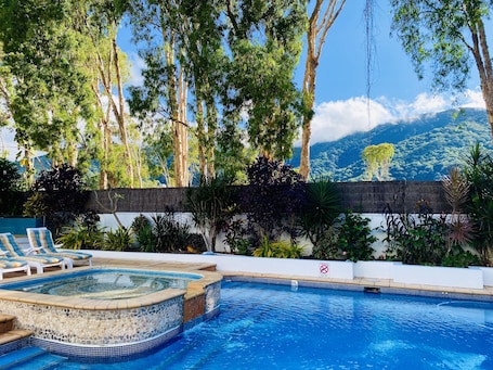 Outdoor pool, pool loungers. BeachView Apartments at Villa Paradiso