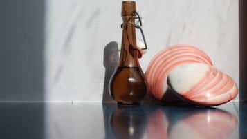 Una botella y un plato de cerámica sobre una superficie reflectante.