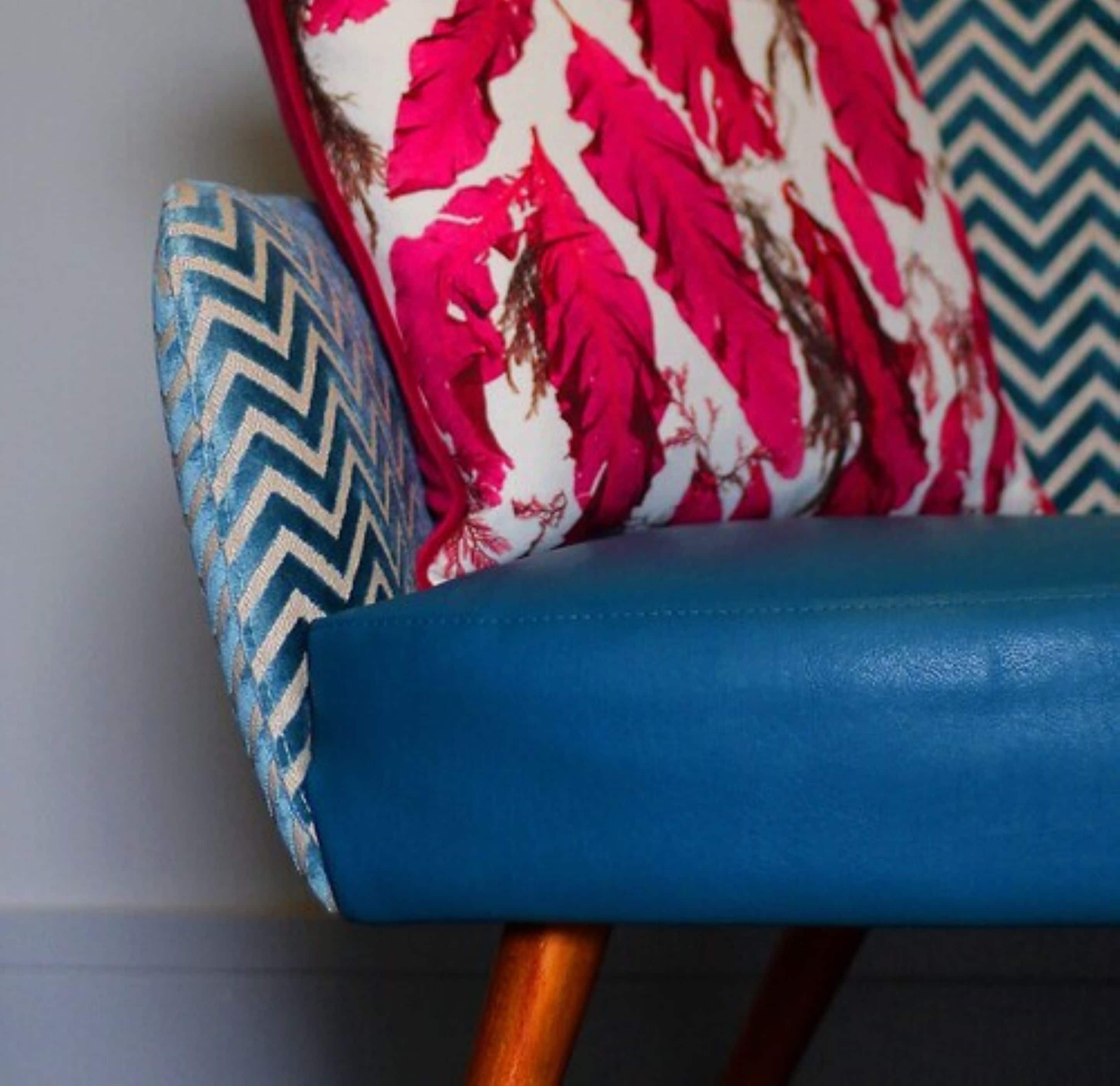 A chair with a blue seat and a patterned backrest.