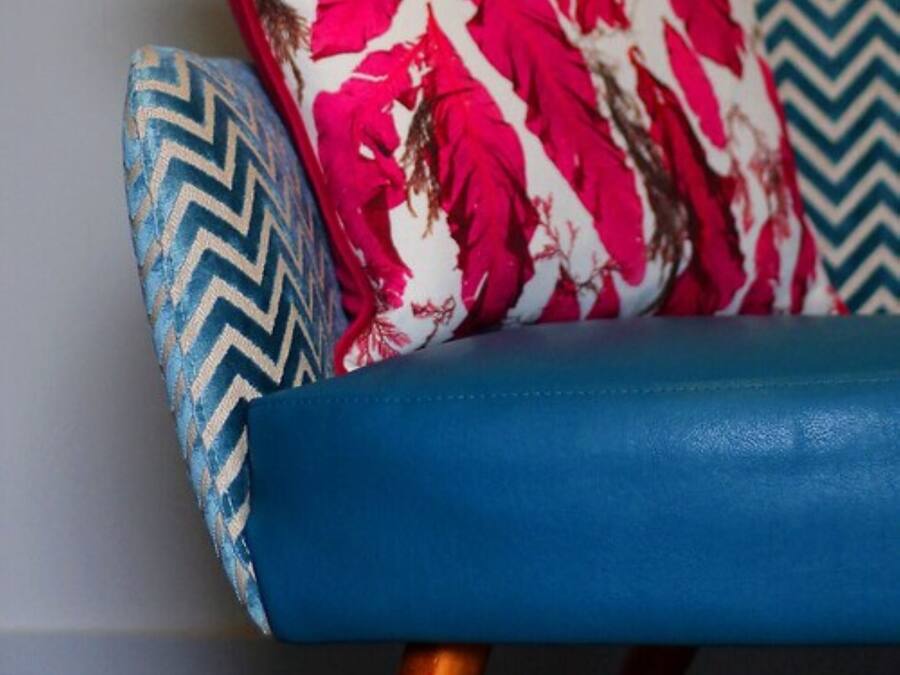 A chair with a blue seat and a patterned backrest.