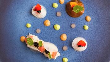 Un plato azul con diferentes piezas de sushi y guarniciones.