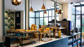 A breakfast buffet with bread, fruits, and beverages.