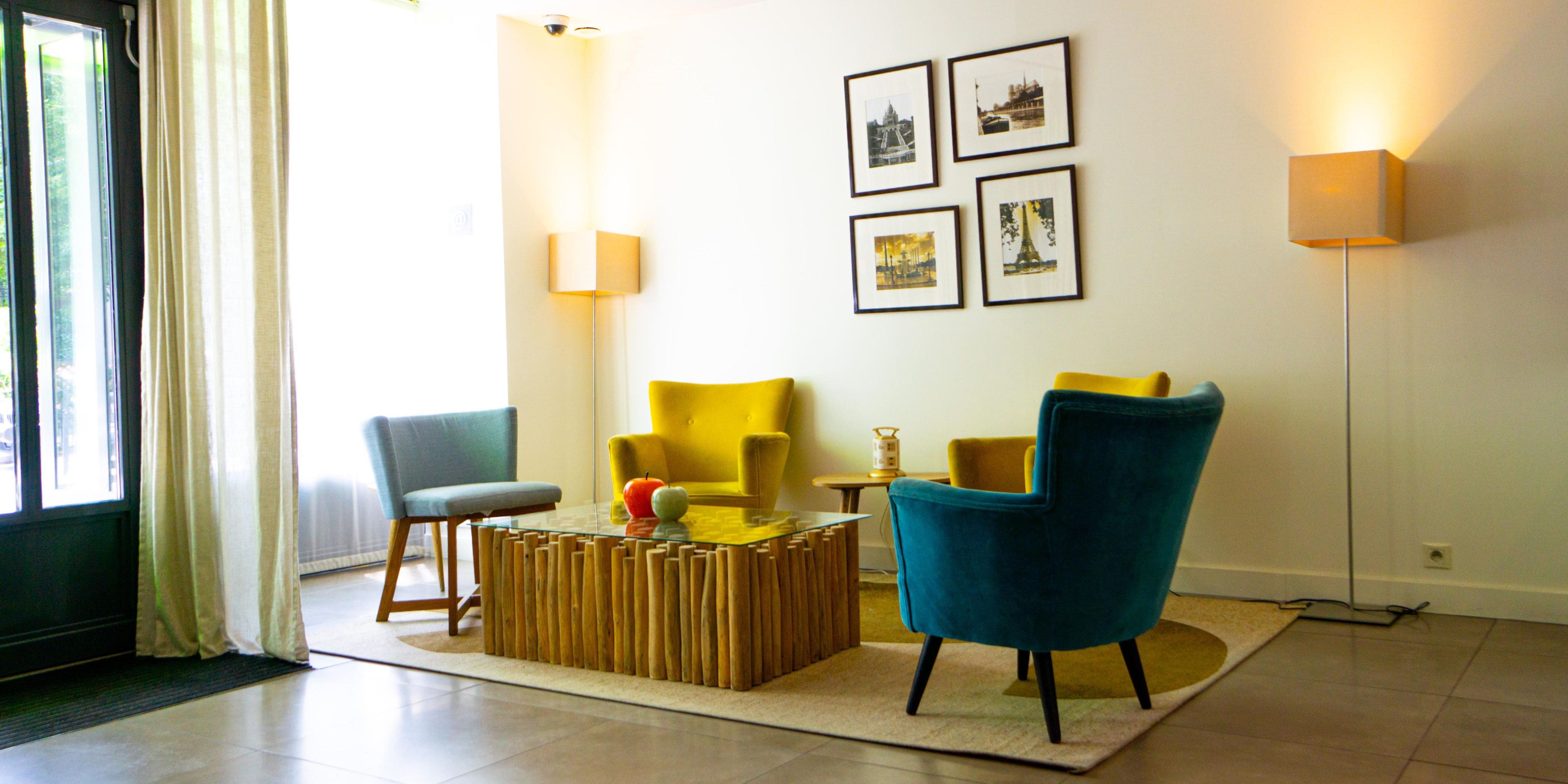 Uma sala de estar moderna com um sofá, poltronas, uma mesa de centro e quadros nas paredes.