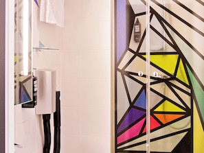 Bathroom features a geometric stained glass shower door and a hairdryer mounted on the wall.