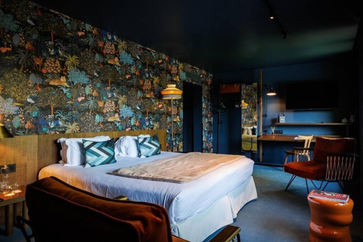 A hotel room with a bed, a desk, and a chair.