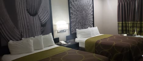 A hotel room with two beds, a nightstand, a lamp, and a patterned wall.