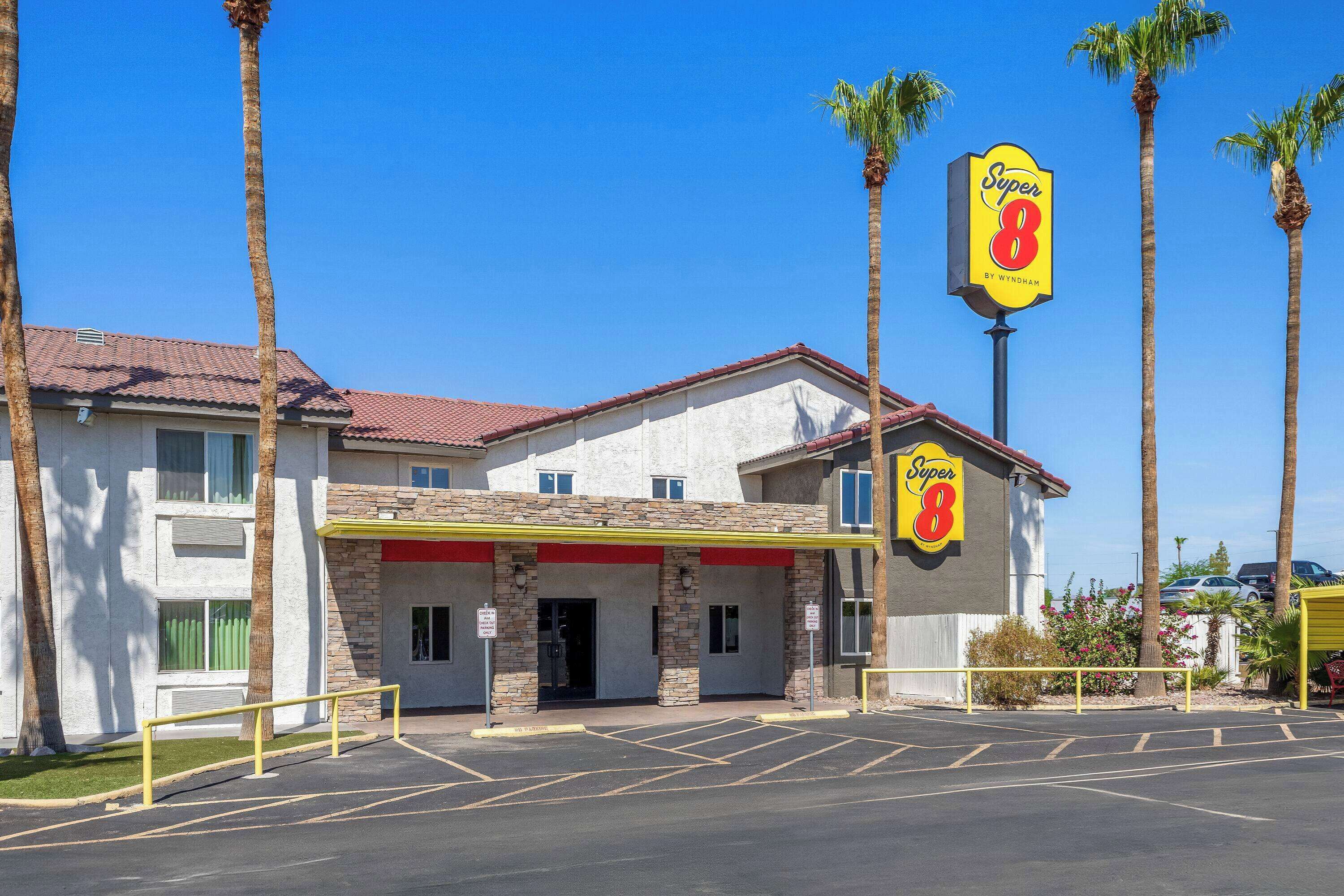 A Super 8 motel with a red roof, stone facade, and a parking lot.