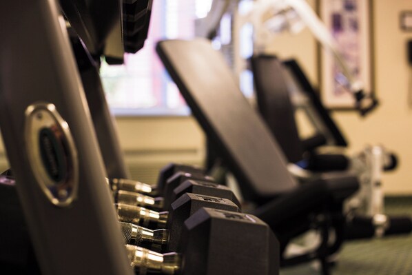 Une vue rapprochée d'appareils de musculation, notamment des machines à poids et des haltères.