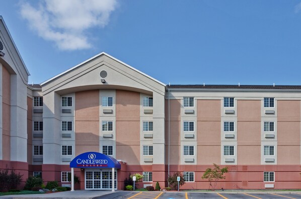 Un hotel con un llamativo letrero de 'Candlewood Suites', varios pisos y un estacionamiento.