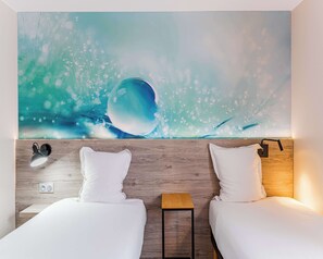A hotel room with two beds, a wooden headboard, a nightstand, a wall-mounted lamp, and a large abstract painting. - KYRIAD DIRECT Tours Sud - Chambray Lès Tours (Chambray-les-Tours)