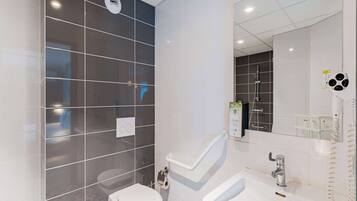Un baño moderno con inodoro, lavamanos y ducha.