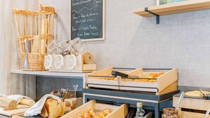 A bakery display with various baked goods, jars of honey, and a chalkboard menu. - KYRIAD DIRECT Tours Sud - Chambray Lès Tours (Chambray-les-Tours)