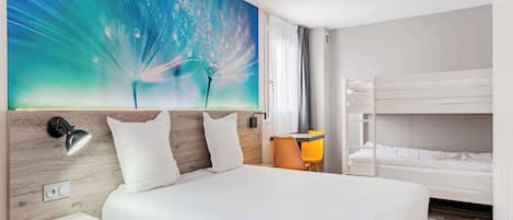 A hotel room with a large bed, a desk with a chair, a bunk bed, and a wall with a blue abstract painting.