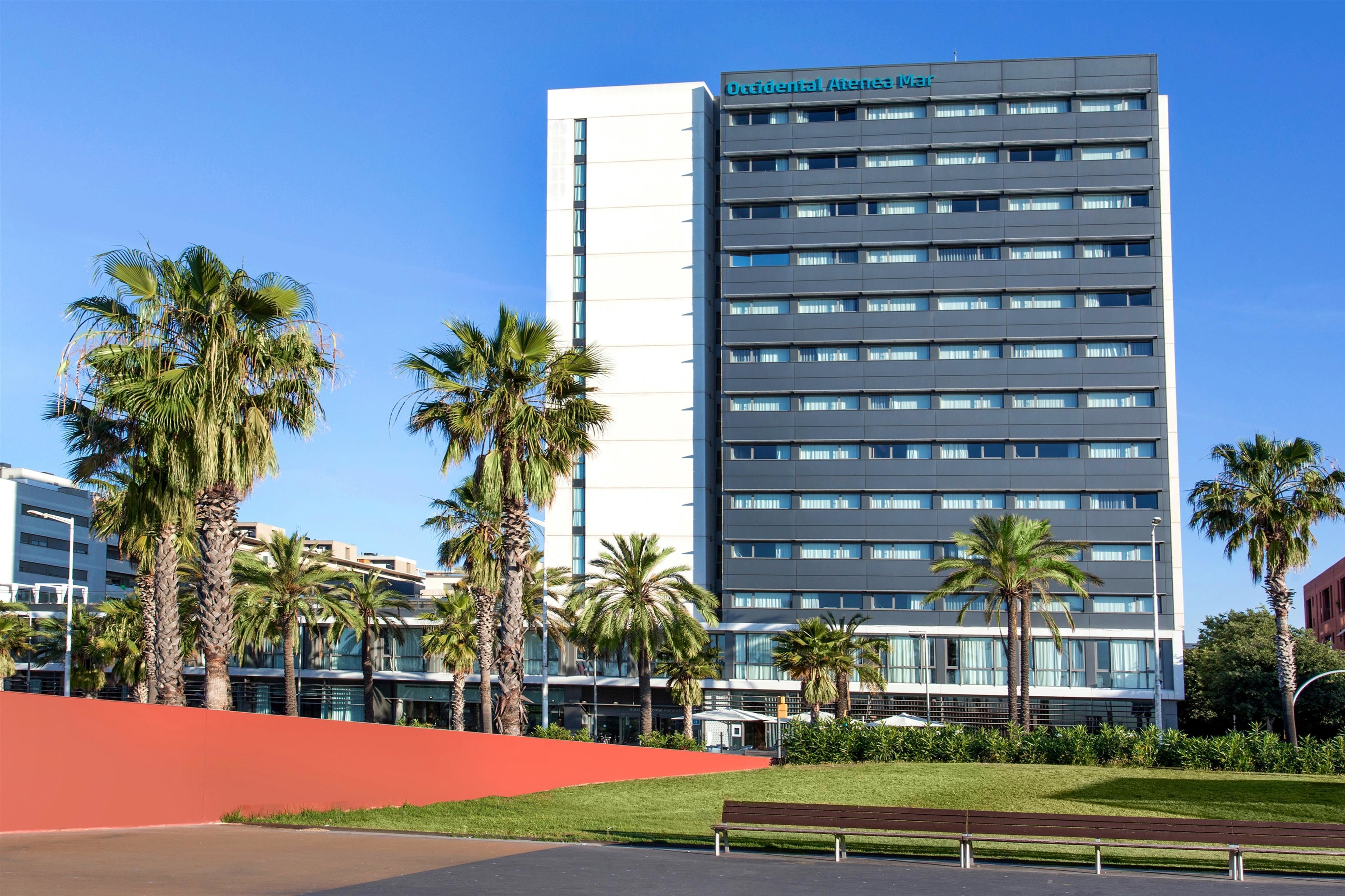 A modern hotel with a flat facade, multiple floors, and a prominent sign.