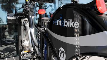Una bicicleta con estructura negra y blanca, un portaequipajes trasero y un adhesivo con el número 97.