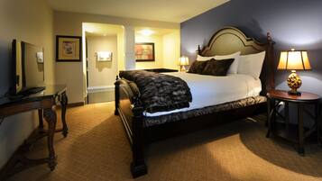 A hotel room with a large bed, bedside tables, a desk, and a lamp.