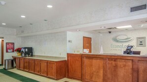 A reception area with a wooden counter, a coffee machine, and a sign for EconoLodge by Choice Hotel. - Econo Lodge Weatherford (Weatherford)