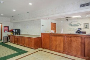 Zona de recepción con mostrador de madera, una máquina de café y un cartel de EconoLodge by Choice Hotel.