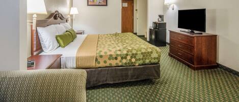 A hotel room with a bed, a television, a dresser, and a sofa.