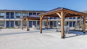 A hotel courtyard with outdoor seating and a covered area. - Motel 6 Elizabethtown, KY (Elizabethtown)