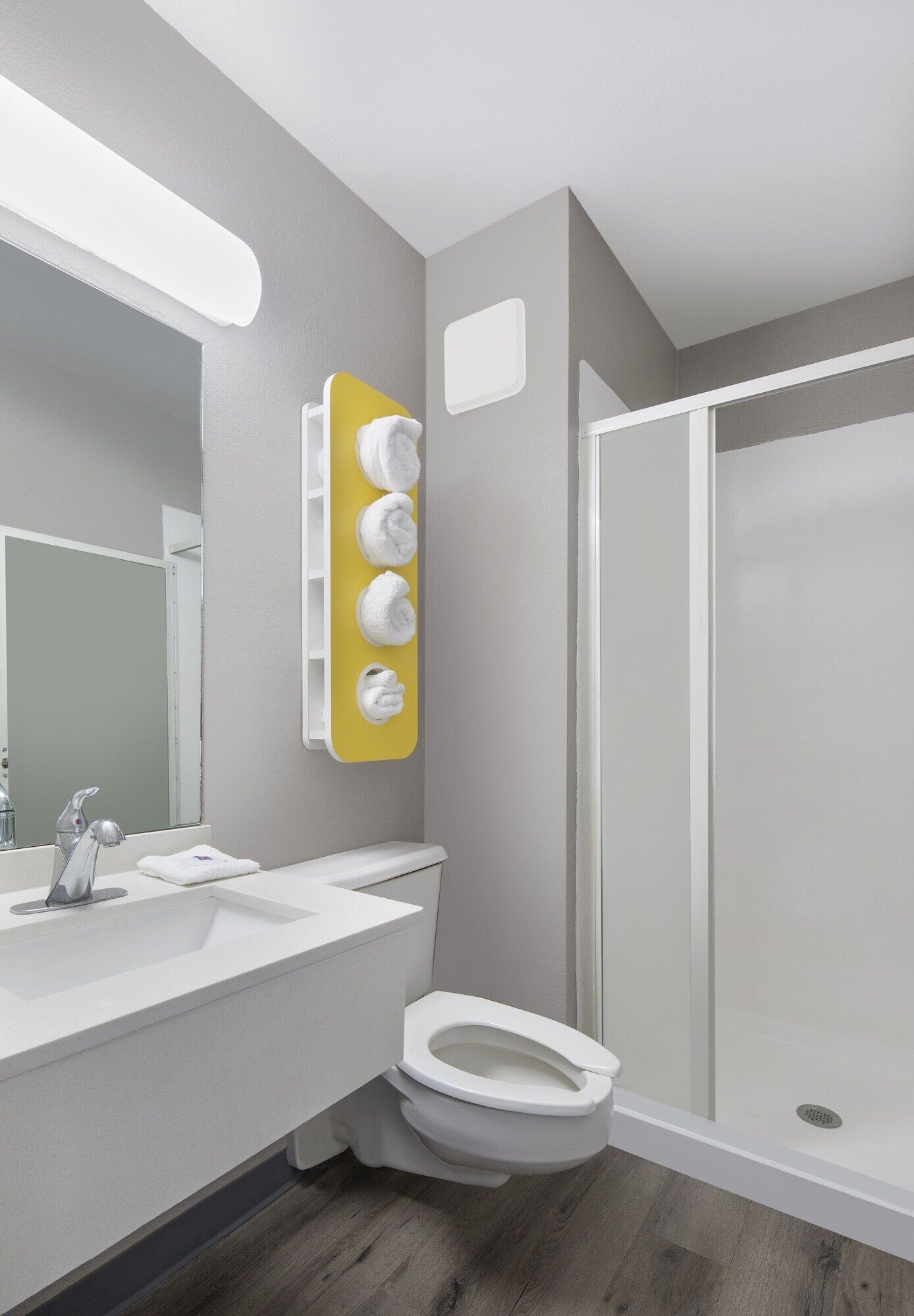 Une salle de bain moderne avec un lavabo blanc, des toilettes et une douche à parois de verre.