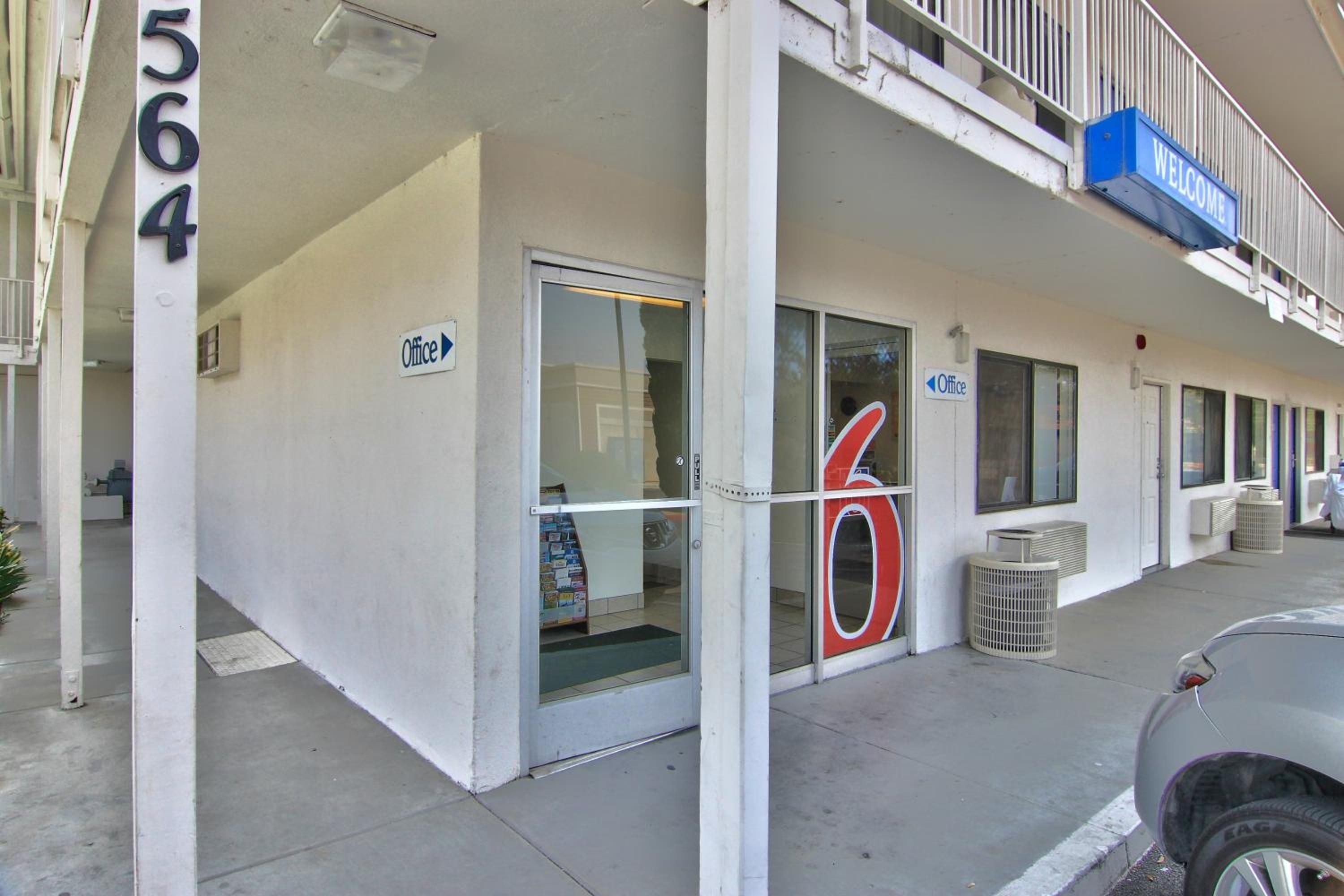 A building with a numbered entrance, a glass door, and a sign indicating an office.