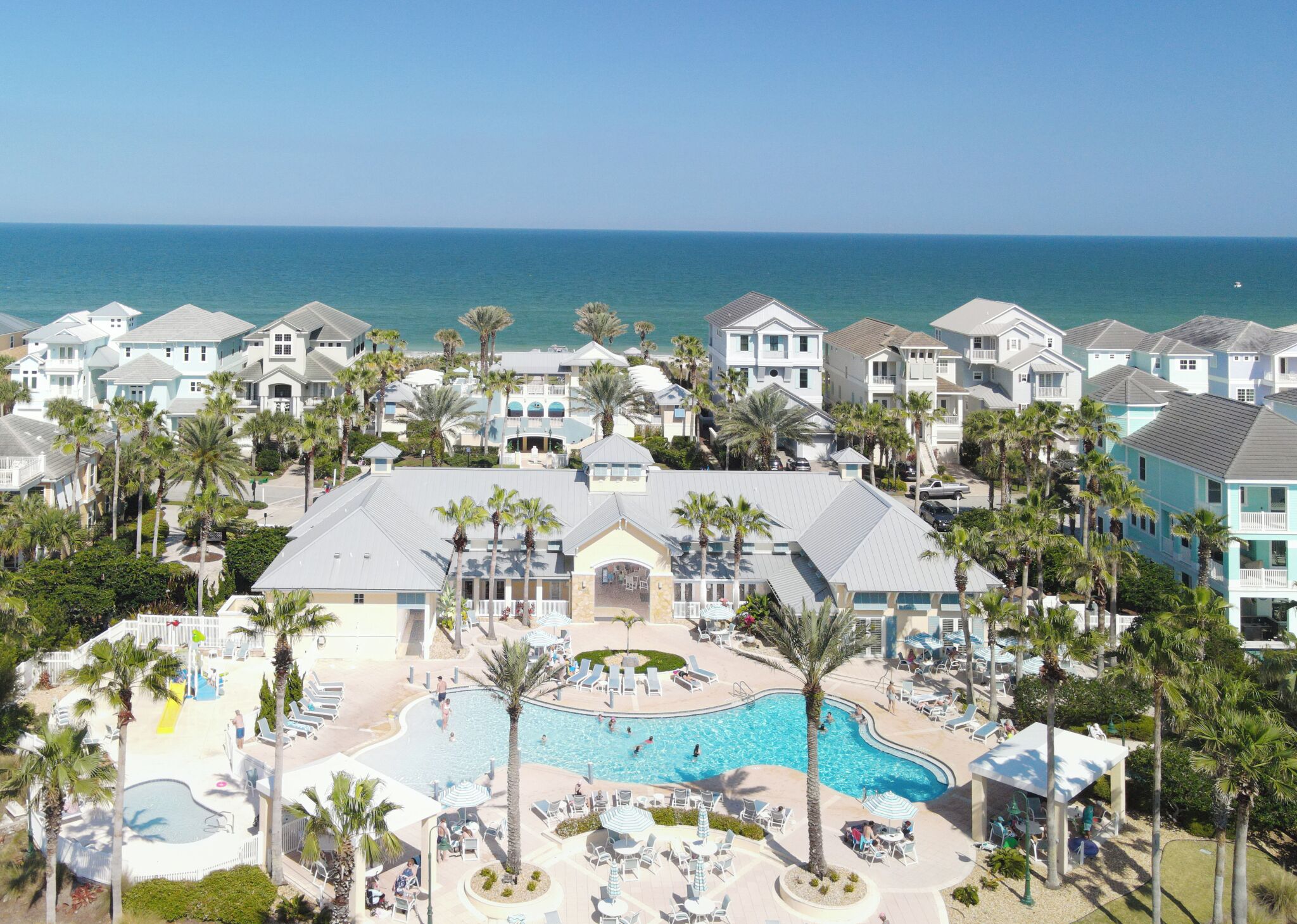 A resort with a swimming pool, palm trees, and ocean views.
