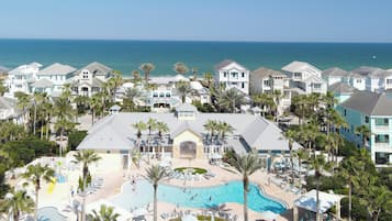 A resort with a swimming pool, palm trees, and ocean views.