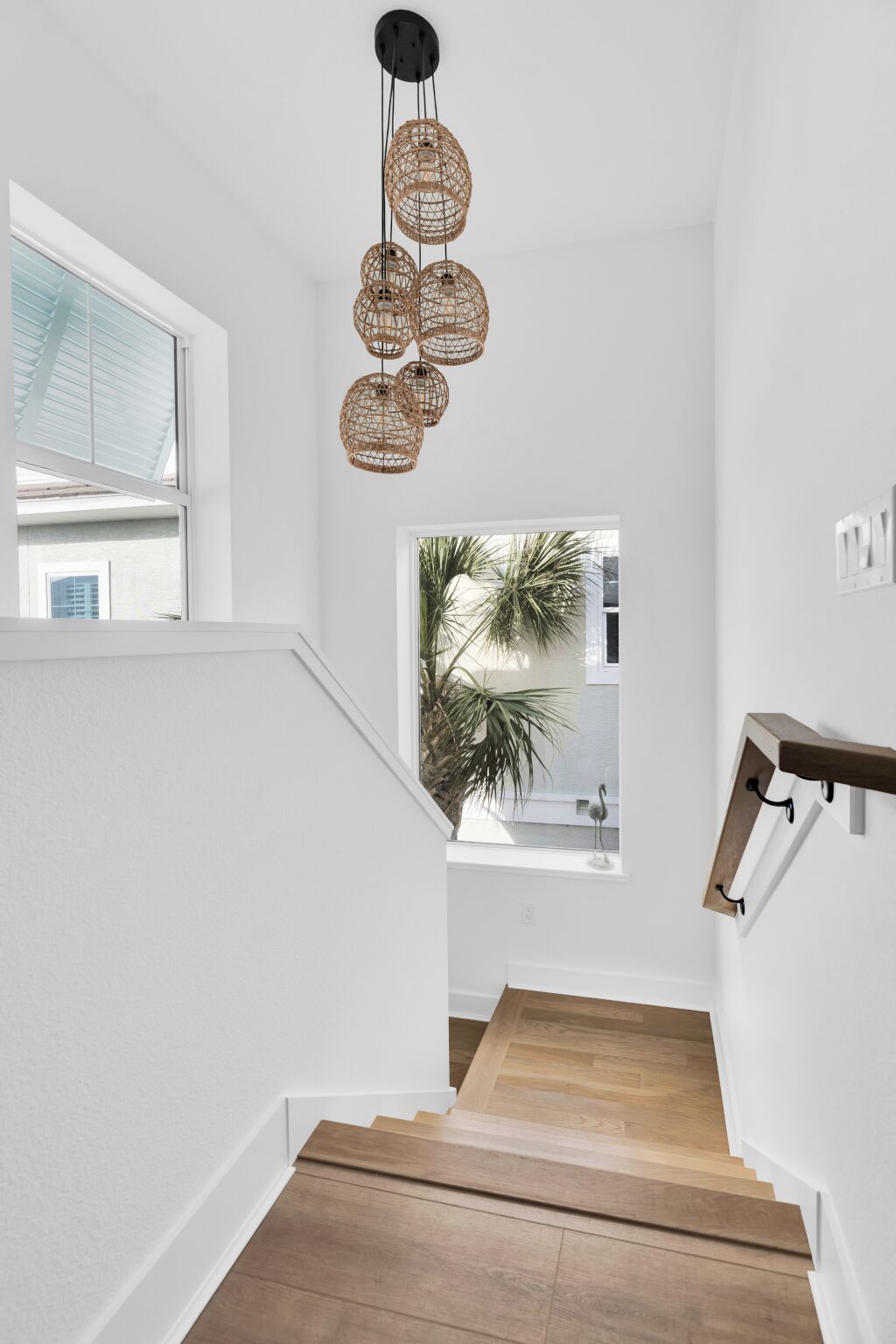 A staircase with wooden steps and a woven light fixture.