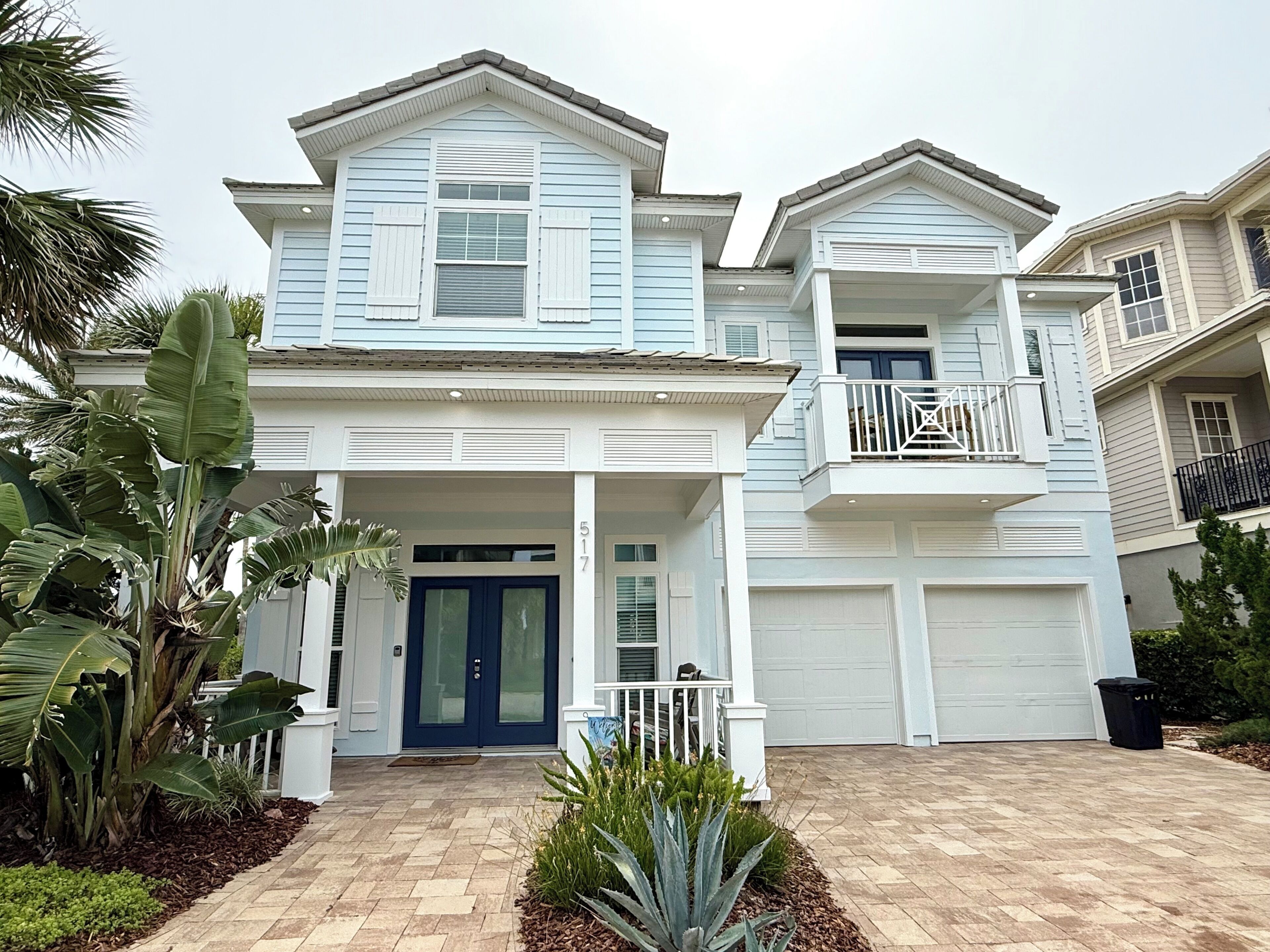 A two-story house with a front porch, a garage, and a balcony.