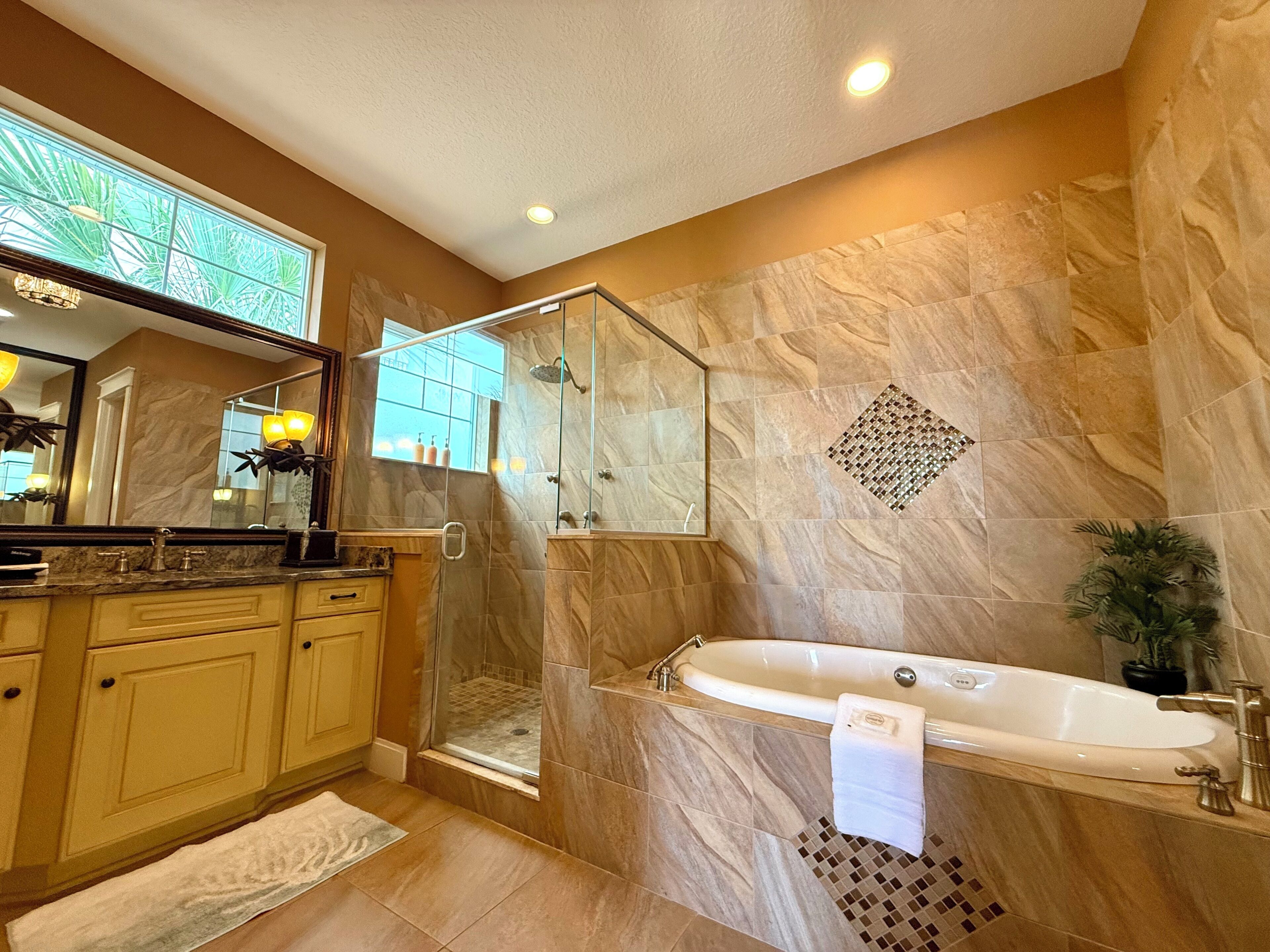 A modern bathroom with a glass-enclosed shower, a freestanding bathtub, and a large mirror.
