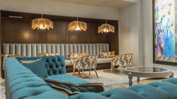 A modern living room with a sectional sofa, a round coffee table, and patterned chairs.