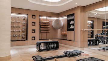 Une chambre d’hôtel moderne dotée d’un espace dédié à la pratique sportive, comprenant du matériel d’exercice et un porte-chaussures.