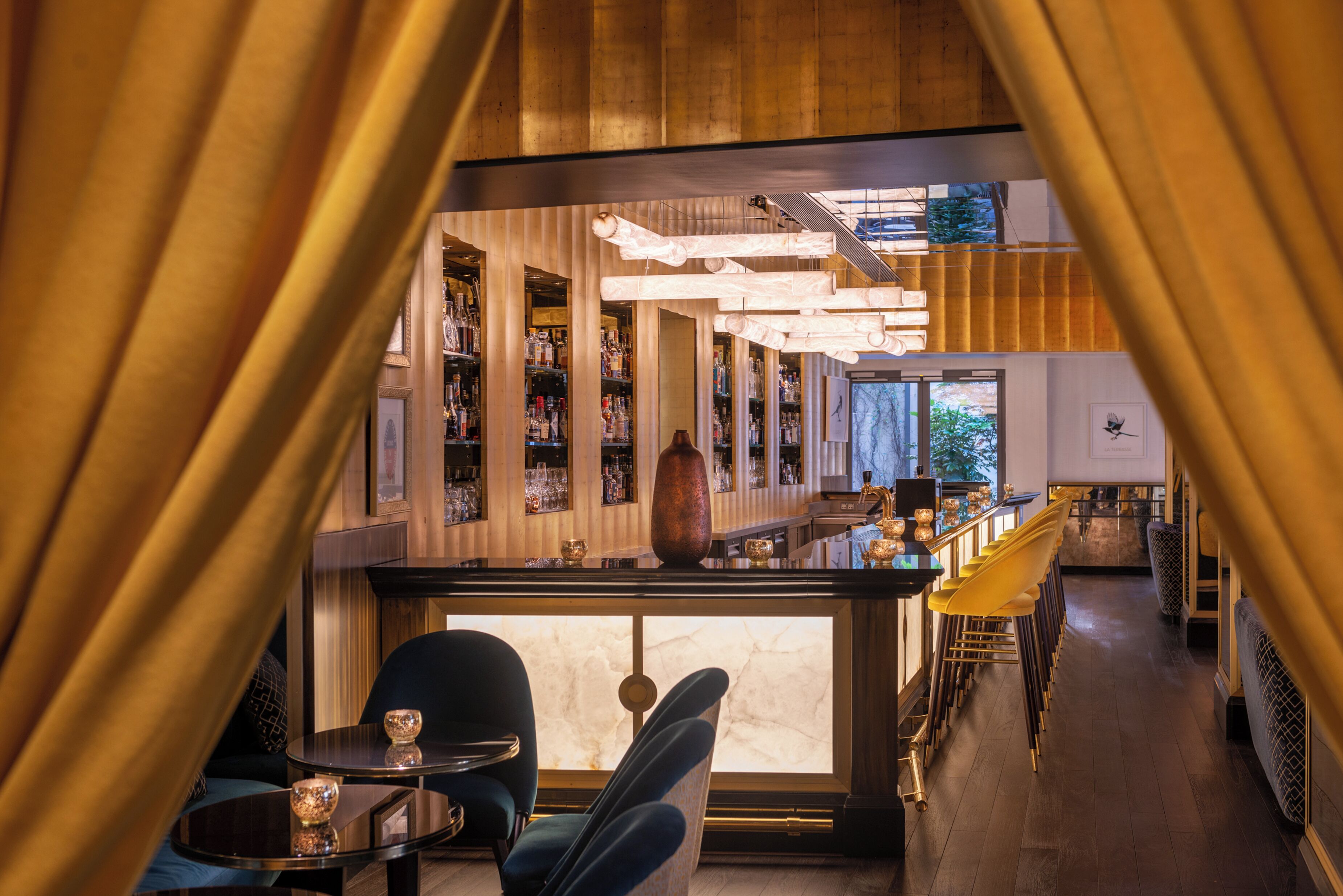 A bar area with a long counter, bar stools, and a seating area with tables and chairs.