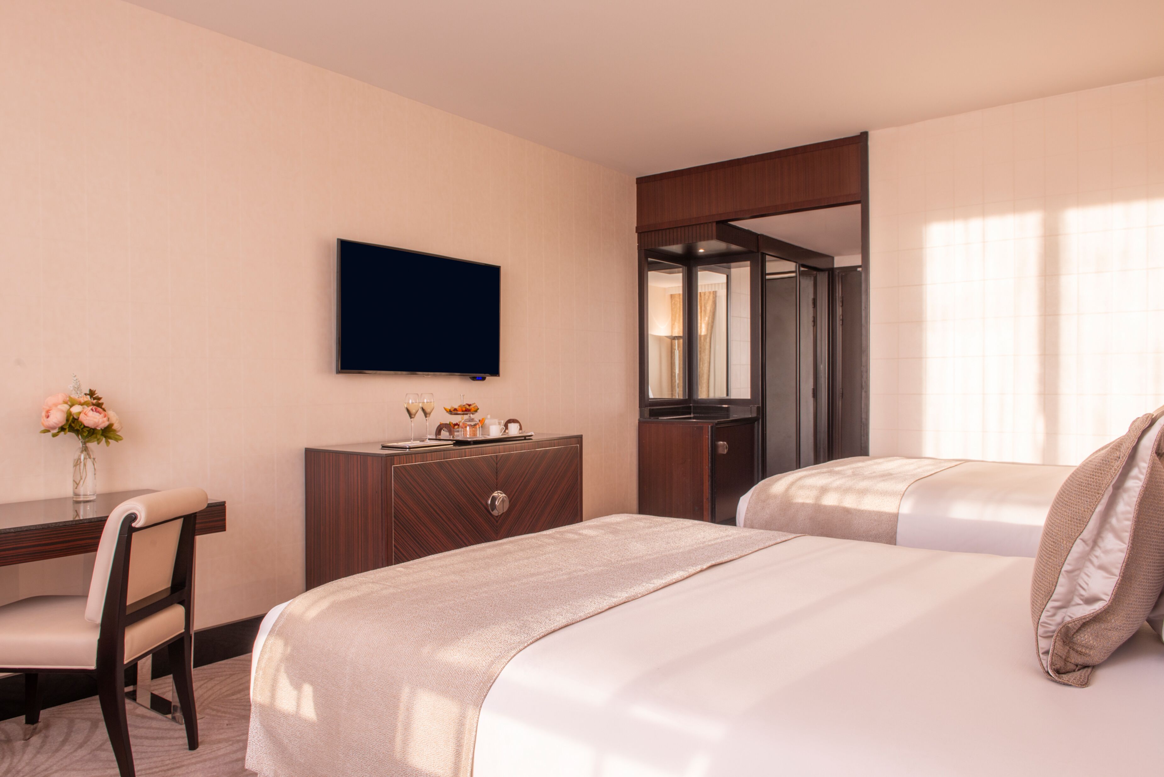 A hotel room with a bed, a desk with a chair, a television, and a mirror.