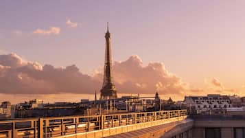 A view of the Eiffel Tower with a bridge in the foreground.