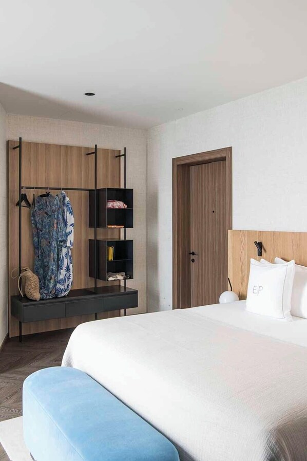 A modern hotel room with a large bed, a wooden wardrobe, and a small seating area. - Hotel Europa (Sanremo)